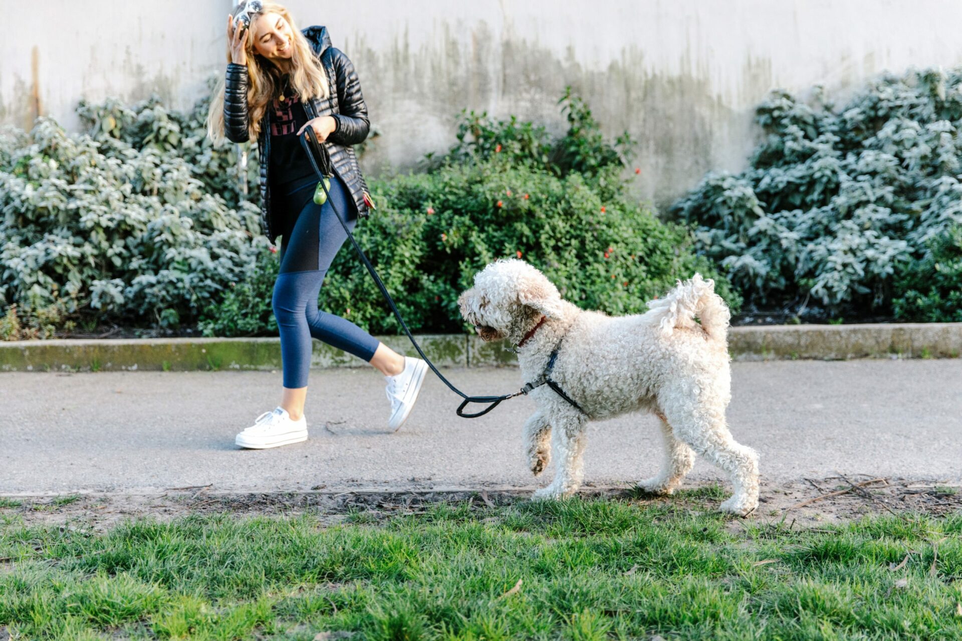 girl smiling and walking dog